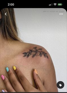 a woman's shoulder with colorful nail polishes and a tattoo on her left arm