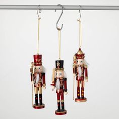 three wooden nutcrackers hanging from hooks