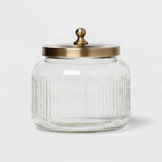 a glass jar with a brass lid