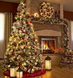 a decorated christmas tree in front of a fireplace