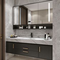 a modern bathroom with marble counter tops and dark wood cabinetry, along with large mirrors