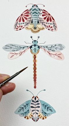 a person holding a pen and drawing on paper with different types of insects in it