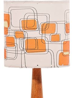 an orange and white lampshade on a wooden base with a square shaped lamp shade