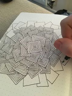 someone is drawing something on paper with a pen and inking it in the shape of a maze