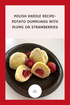 a black plate topped with dumplings and strawberries on top of a white table