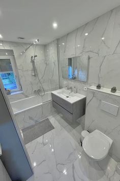 a bathroom with white marble walls and floors