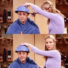 the man is getting his hair cut by the woman in the blue robe and hat