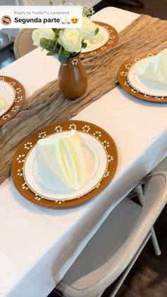 the table is set with white and gold place settings for two people to sit at