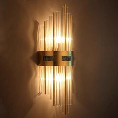 a wall light that is made out of glass tubes and has lights on each side