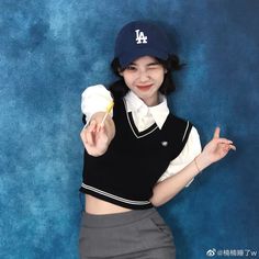 a woman in a baseball cap is posing for the camera and holding a doughnut