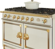 a white and gold stove with a pot on top