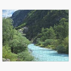 a jigsaw puzzle with a river in the middle surrounded by trees and mountains