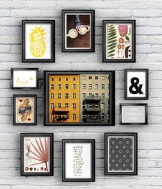 a white brick wall with black framed pictures on it