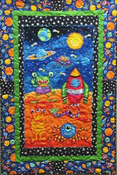 a quilted wall hanging with an image of space