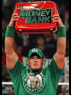 a man holding up a red briefcase over his head in front of an audience at a money bank event