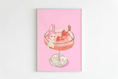 a pink card with an image of a drink and bunny on the top, in front of a white background