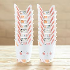 there are many paper cups that have bunny ears on them with carrots sticking out of them