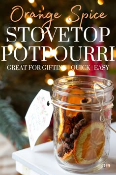 an orange spice stovetop potpoure in a glass jar on top of a table