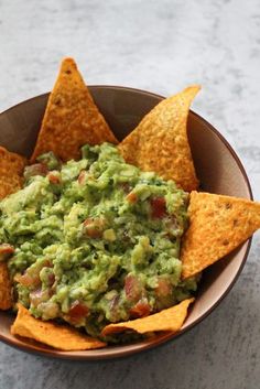 a bowl filled with guacamole and tortilla chips