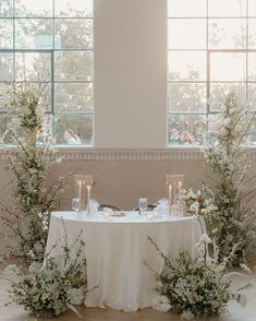 the table is set with candles, flowers and greenery for an elegant wedding reception