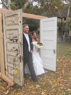 a man and woman are walking out of an open door