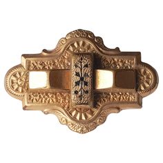 an ornate gold door handle on a white background