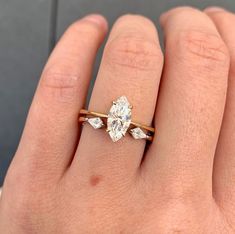 a woman's hand with a diamond ring on top of her finger and an engagement band