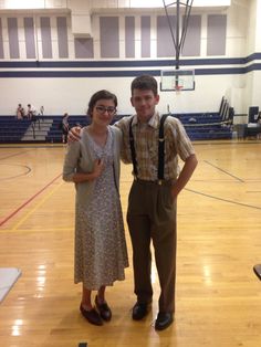 a young man and woman standing on a basketball court posing for the camera with their arms around each other