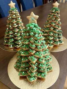 three christmas trees made out of cookies sitting on top of each other in front of a wooden table