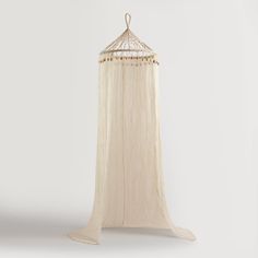 a white bed canopy with beads hanging from it's sides and an open top