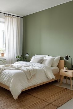 a bedroom with green walls and white bedding