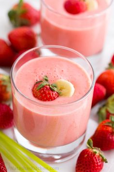 two glasses filled with smoothie and strawberries