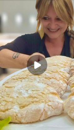 a woman smiles as she looks at some bread