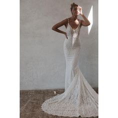 a woman in a white wedding dress posing for the camera with her hand on her head