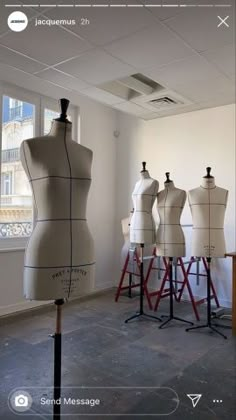 several mannequins are lined up in an empty room