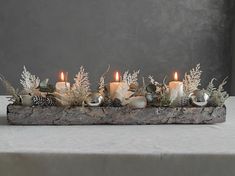 an arrangement of candles and flowers on a table