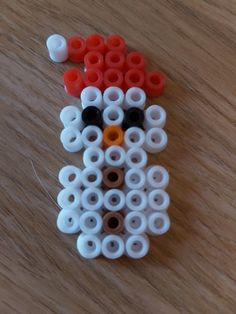 a close up of a beaded animal on a wooden surface with beads around it