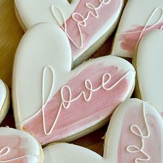 some heart shaped cookies with the word love painted on them