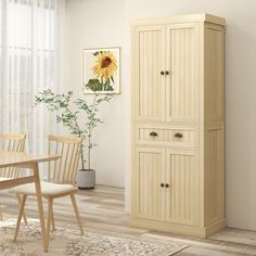 a room with a table, chairs and a cabinet in the corner that has a sunflower on it