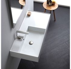 a white sink sitting next to a window in a bathroom on top of a wooden floor