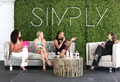 three women sitting on couches in front of a wall with the word simply written on it