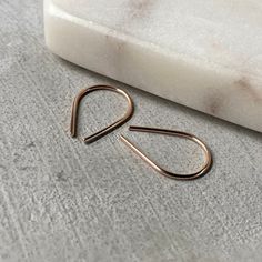 Tiny horseshoe everyday threader earrings are hand formed and left round for a clean sleek look. You can wear them open or insert and squeeze the ends together for a teardrop look. Comfortable enough to sleep in. Made from 19 gauge wire, slightly thicker than most ear wires but still very comfortable. 3/4 inch long, (19mm) Available in 14k Gold or Rose Gold filled, and Argentium silver (935 tarnish resistant silver) making these a great option for sensitive ears. Each piece is handmade so there Minimalist Small Hoop Threader Earrings, Minimalist Teardrop Threader Earrings For Everyday, Minimalist Teardrop Cartilage Earrings, Minimalist Nickel-free Teardrop Threader Earrings, Minimalist Paperclip Hoop Earrings For Everyday Wear, Minimalist Teardrop Cartilage Earrings With Ear Wire, Minimalist Paperclip Hoop Earrings For Everyday, Minimalist Teardrop Wrap Earrings, Modern Minimal Jewelry