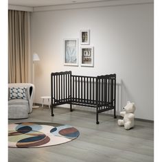 a baby crib sitting in the corner of a room next to a teddy bear