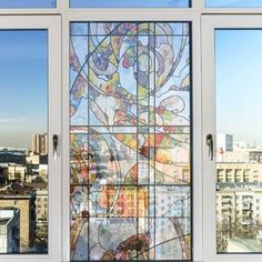 a large stained glass window in the middle of a building with cityscape behind it