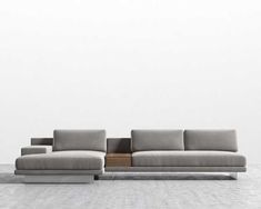 a gray couch sitting on top of a white floor