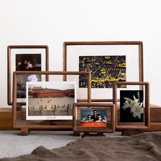 there are four frames on the floor with pictures in them and one is holding photos