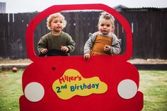 two children in a red car shaped birthday card