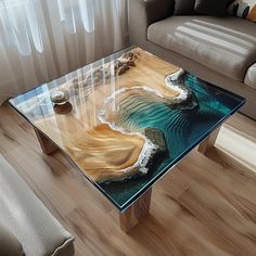 a glass coffee table with an ocean scene on the top and waves painted on it