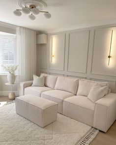 a living room filled with furniture and a large white rug on top of a hard wood floor