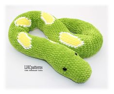 a green stuffed snake with yellow and white spots